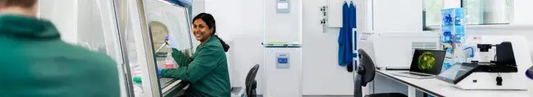Research smiling at colleague in tissue culture lab
