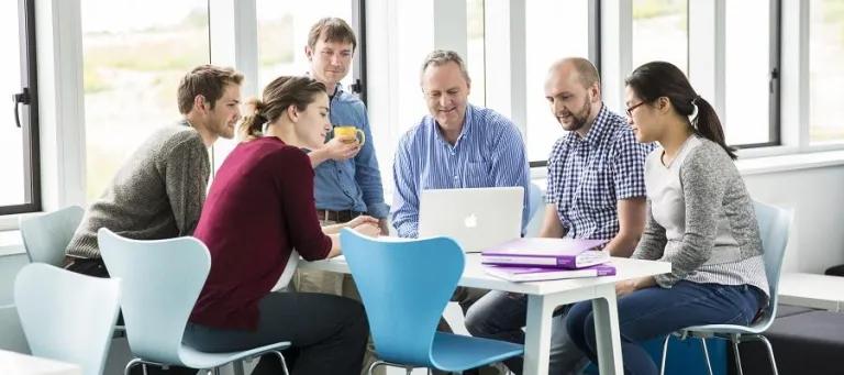 Group of researchers around a laptop